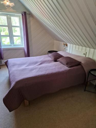 a bedroom with a large bed in a attic at Idyllisk feriested in Røyksund