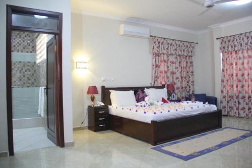 a bedroom with a large bed and a window at Gold Plus Hotel Ghana in Kumasi