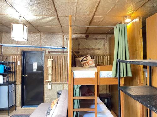 a room with two bunk beds and a door at Galera Lodge in Puerto Galera