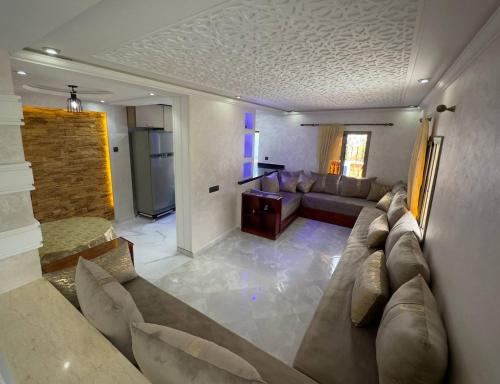 ein großes Wohnzimmer mit einem Sofa und einer Küche in der Unterkunft Duplex panoramique avec jardin in Chefchaouen