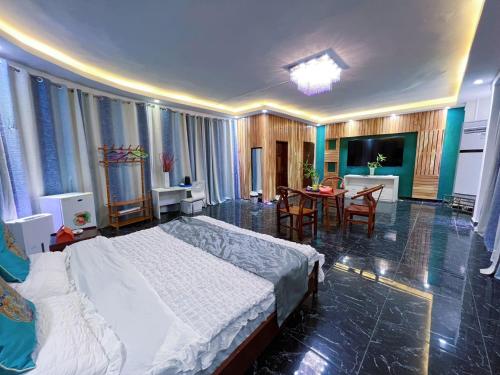 a bedroom with a bed and a dining room with a table at Grand Leone Hotel in Freetown