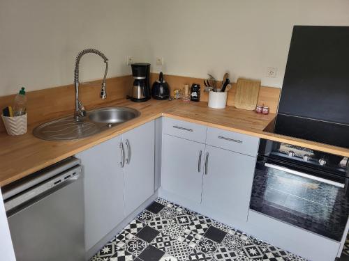 a kitchen with white cabinets and a sink at Maison de Village avec Jardin, Parc Privé et Box Fibre, Animaux Bienvenus, à 15 min du Mans - FR-1-410-333 in Mézières-sous-Lavardin