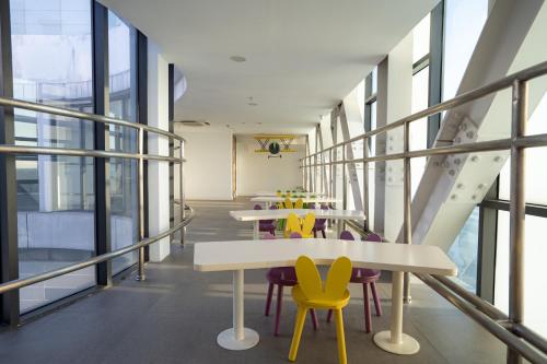 a cafeteria with tables and yellow chairs in a building at APARTMENT AIRPORT TAN SON NHAT - free Pool & Gym in Ho Chi Minh City