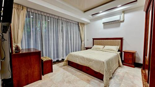 a bedroom with a bed and a large window at Villa 7 bedrooms in Ban Mai Salae