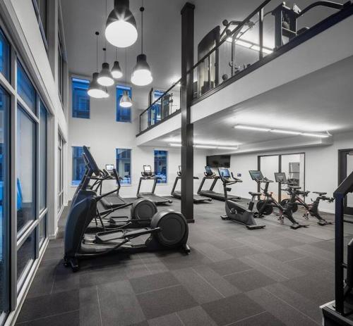 a gym with several treadmills and elliptical machines at KING BED One-Bedroom Retreat in Wauwatosa
