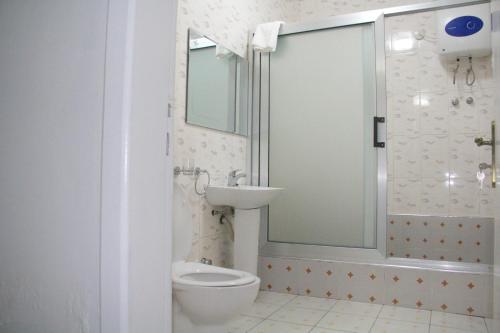 y baño con aseo, lavabo y ducha. en Gold Plus Hotel Ghana en Kumasi