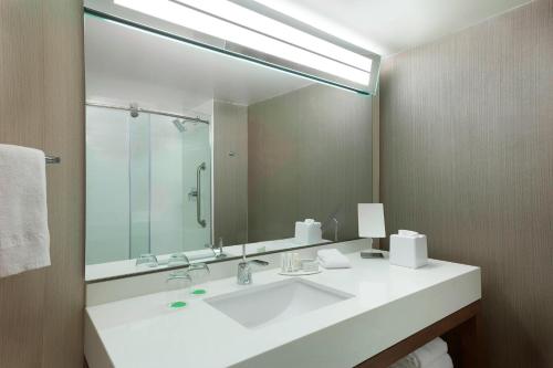 a bathroom with a sink and a large mirror at Courtyard by Marriott Toronto Northeast/Markham in Markham