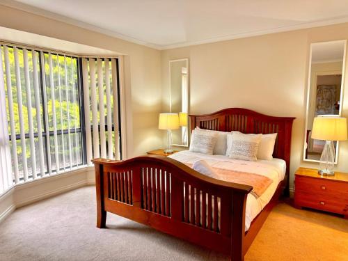 1 dormitorio con 1 cama grande y 2 ventanas en Adelaide Hills 4 bed home near Hahndorf Mt Barker, 
