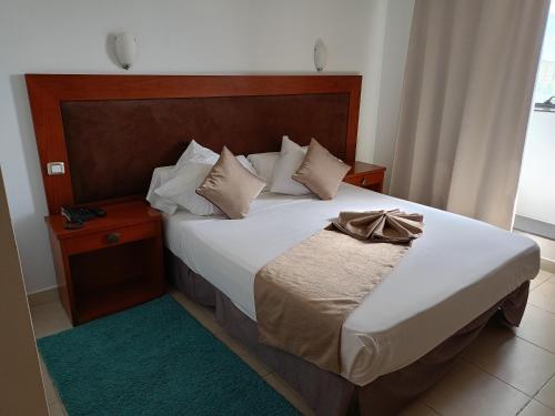 een slaapkamer met een bed met een boog erop bij Hôtels Jardy in Bab Ezzouar