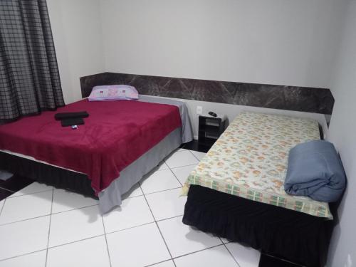 um quarto com uma cama e uma cama sidx sidx em POUSADA ALTERNATIVA MANU LAGES suite em Lages