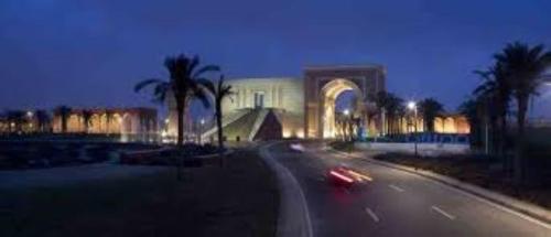 une rue de la ville avec un bâtiment et des palmiers la nuit dans l'établissement The most luxurious, most wonderful location in Egypt, New Cairo, Madinaty Resort, air conditioning, free internet الافخم أروع موقع مصر القاهرة الجديدة منتجع مدينتي مكيفة انترنت مجاني, à Madinaty