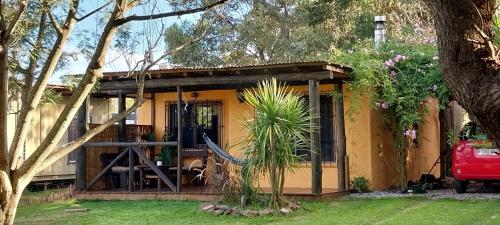 ein kleines gelbes Haus mit einer Veranda in der Unterkunft Gotas de Rocio in Piriápolis