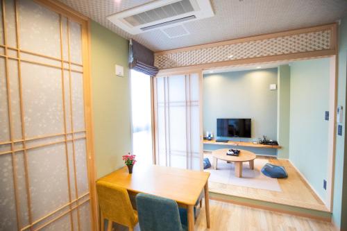 a dining room with a table and a television at SOLA HOTEL in Tokyo
