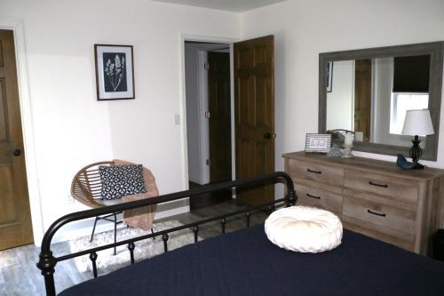 Schlafzimmer mit einem Bett, einer Kommode und einem Spiegel in der Unterkunft Country Hills Hideaway in Millersburg