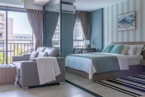 a bedroom with a bed and a couch at YES! LaCasita Pool View 5 FREE WiFi near the sea in Hua Hin