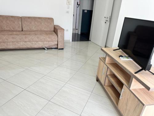 a living room with a couch and a flat screen tv at Hotel Ersi in Shëngjin