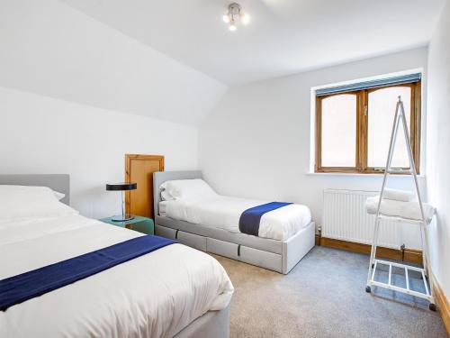 Un dormitorio con 2 camas y una escalera. en Total Retreat en Isle of Sheppey