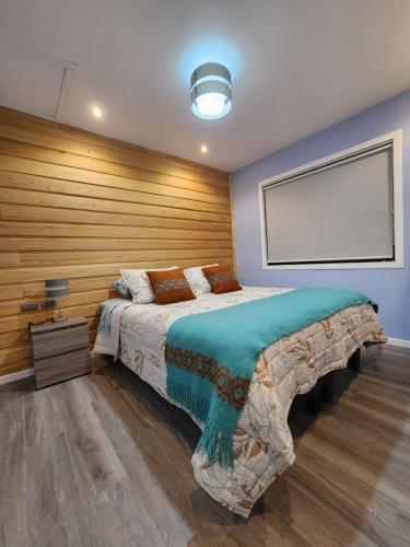 克利翁的住宿－Cabañas Pewmawapi，一间卧室设有一张带木墙的大床
