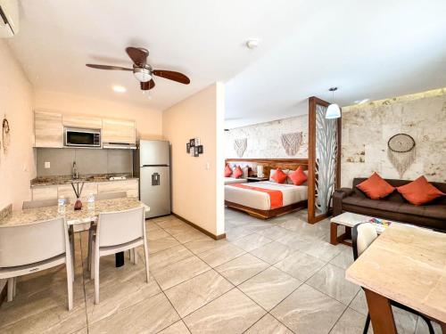 a hotel room with a bed and a living room at Grand Fifty Suites in Playa del Carmen