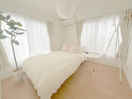 Habitación blanca con cama y mesa en 渋谷3分でベット4台の3ベットルーム65平米の一軒家, en Tokio