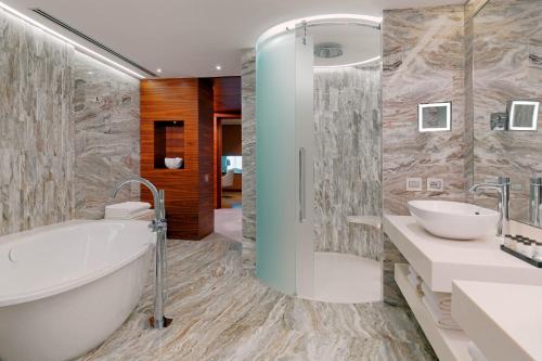 a bathroom with a tub and two sinks and a bath tub at Sheraton Annaba Hotel in Annaba