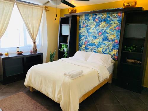 a bedroom with a bed with a painting on the wall at Casa Bonita in Guadalajara