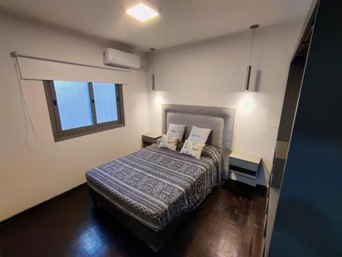 a bedroom with a bed and a window at Emilio es un precioso departamento quinta sección Mendoza in Villa Marini