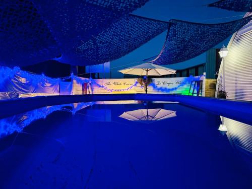 uma piscina com um guarda-sol e uma mesa com guarda-sóis em Maison avec piscine em Antibes