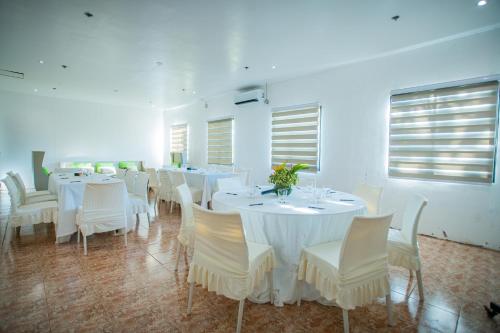 a dining room with white tables and white chairs at Club Agutaya in San Vicente
