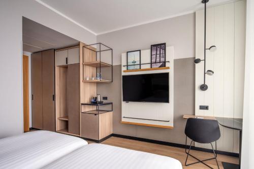 a bedroom with a bed and a television and a chair at Sopot Marriott Resort & Spa in Sopot