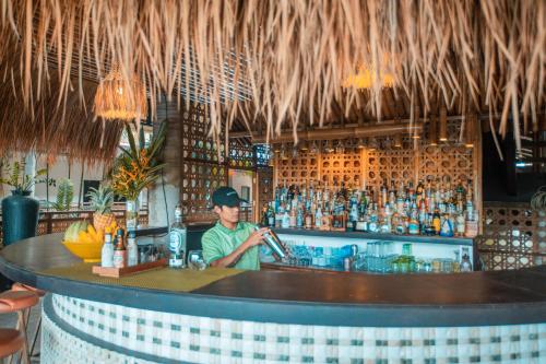 a man bartender behind a bar in a restaurant at Club Agutaya in San Vicente