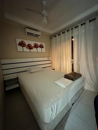 ein Schlafzimmer mit einem großen weißen Bett und einem Fenster in der Unterkunft Maravilhosa Cobertura Apto com Vista para o Mar - Praia da Enseada em Ubatuba in Ubatuba