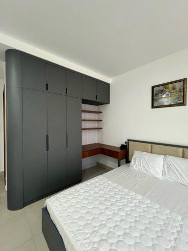 een slaapkamer met een groot wit bed en kasten bij Căn hộ 2 phòng ngủ tầng 10 chung cư cao cấp Sophia Center in Ấp Rạch Mẹo