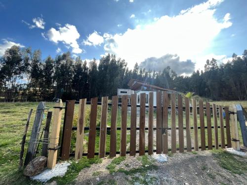 a wooden fence in a field with trees in the background at Casa de Campo Moderna Ubaté - Sector La Laja in Ubaté