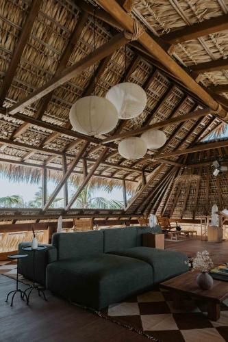 a living room with a green couch and a ceiling at Casa Yuma, Puerto Escondido in Puerto Escondido