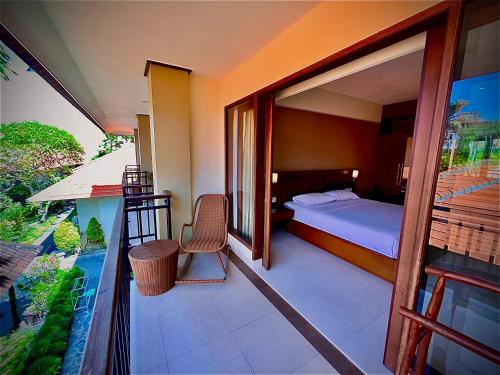 - un balcon dans une chambre d'hôtel avec un lit dans l'établissement Yulia Beach Inn Kuta, à Kuta