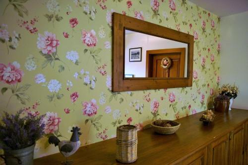 a mirror in a room with flowers on the wall at Farma Moulisových in Nezvěstice
