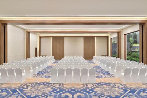 a room with rows of white chairs in a room at Sheraton Grand Bengaluru Whitefield Hotel & Convention Center in Bangalore