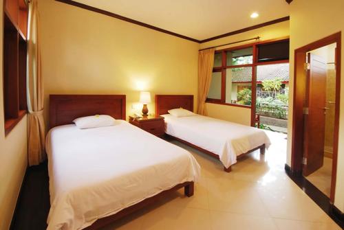 Un ou plusieurs lits dans un hébergement de l'établissement Yulia Beach Inn Kuta