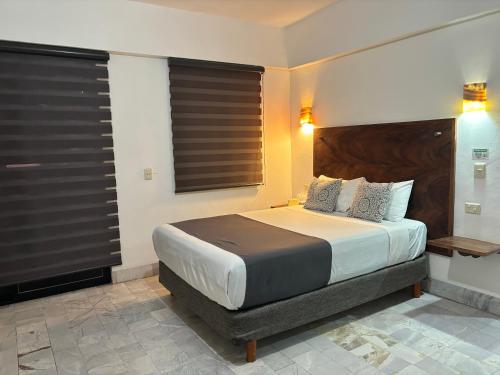 a bedroom with a large bed with black blinds at Ixaya in Puerto Vallarta