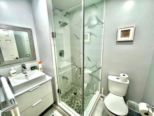 a bathroom with a shower and a toilet and a sink at Cozy house near HWY401 & Go station in Scarborough in Toronto