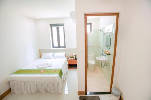 a bedroom with a bed and a bathroom with a shower at ALEX HOTEL and SPA in An Bàn (2)