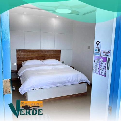 a bedroom with a large white bed in it at Because Verde Resort in Puerto Galera