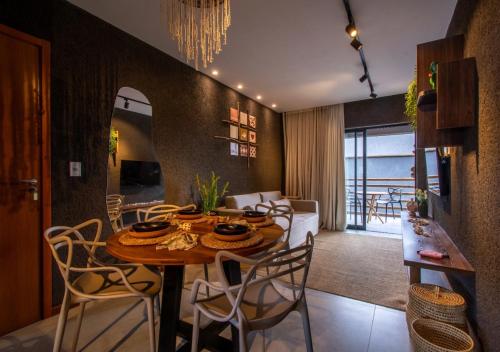 een eetkamer en een woonkamer met een tafel en stoelen bij Apartamento na Praia do Patacho à 190m da praia in Pôrto de Pedras