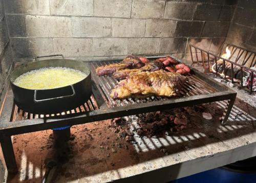 a grill with meat and a pot of food on it at El Establo City Bell - solo alojamiento in City Bell