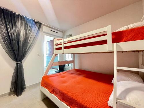 une chambre avec deux lits superposés et une fenêtre dans l'établissement Appartement climatisé 3 pièces avec garage à 300m de la plage et des commerces à Sète - FR-1-338-576, à Sète