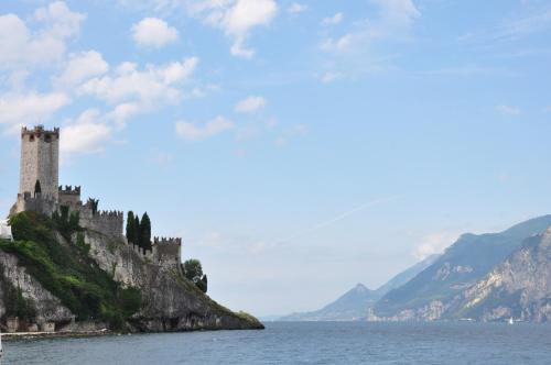 a castle on an island in the water at Hotel Villa Smeralda in Malcesine
