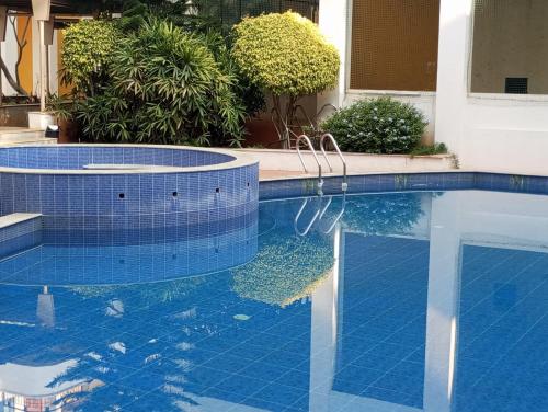 a swimming pool with blue tile in a yard at Amazistay Stay in Bengaluru