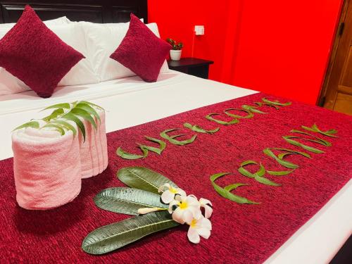 a hotel room with a bed with a red blanket and vegetables at Hema Holiday Villa in Trincomalee