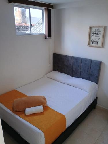 a twin bed in a room with a window at Hotel Cafe Estrella in Armenia